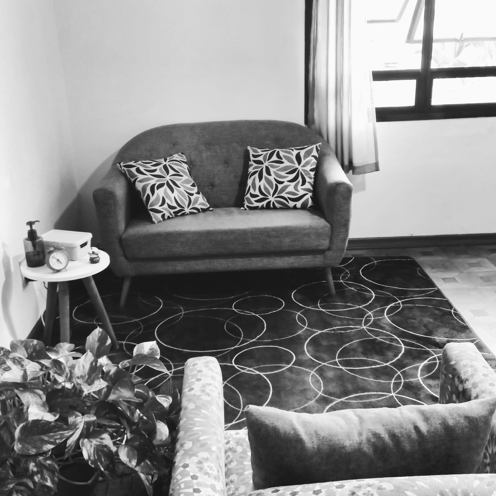 Consultório em preto e branco com poltronas e plantas